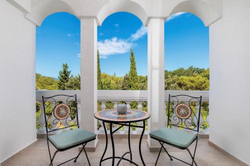 a table and two chairs on a balcony with a view at APARTMENTS JADRANKa in Omišalj