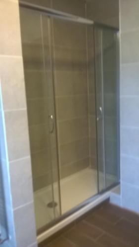 a glass shower door in a room with at Park Hotel Miramonti in Folgaria