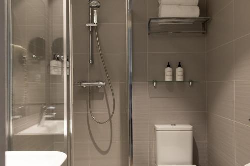 a bathroom with a shower and a toilet and a sink at Colectia Hotel Urumea in Donostia-San Sebastián