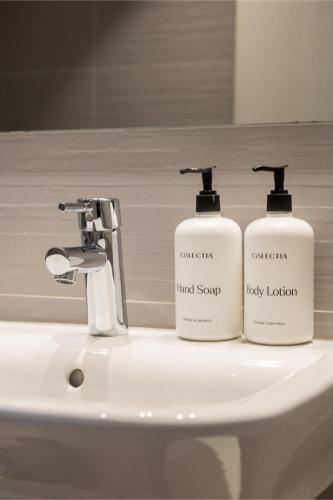 two bottles of soap sitting on top of a bathroom sink at Colectia Hotel Urumea in Donostia-San Sebastián
