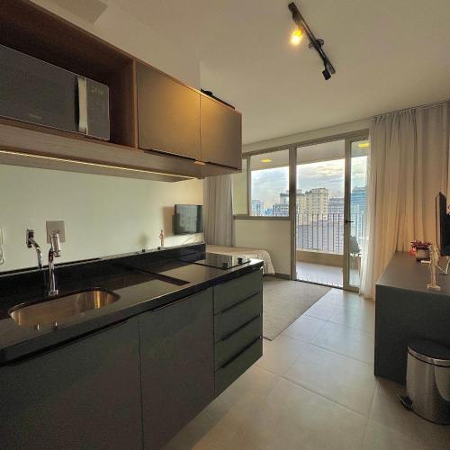 a kitchen with a sink and a large window at Apartamentos Prime - Jardins in Sao Paulo