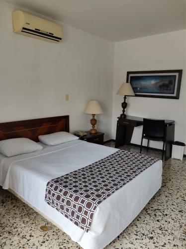 a bedroom with a bed and a desk and a chair at Hotel Estación by Destino Pacifico in Buenaventura