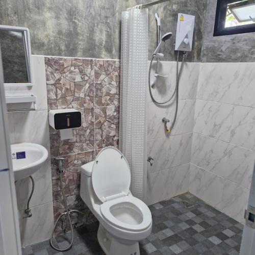 a bathroom with a shower and a toilet and a sink at Baan Raweewan Resort in Ban Phu Yai
