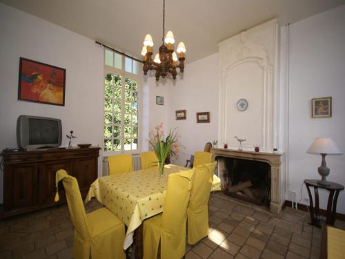 a dining room with a table and chairs and a fireplace at 18th-Century Normandy Stay in Valognes