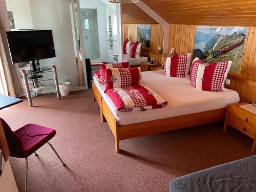 a bedroom with a large bed with red and white pillows at Ruhige Zimmer im Grünen und Studio im Naherholungsgebiet in Sigigen