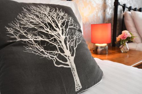 a pillow with a tree painted on it on a bed at The Queens Hotel & Victoria Cloisters Apartments in York