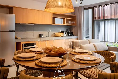 a dining room with a table and a kitchen at Villa Naluri - Seu Refúgio a 50 metros da praia em Japaratinga in Japaratinga