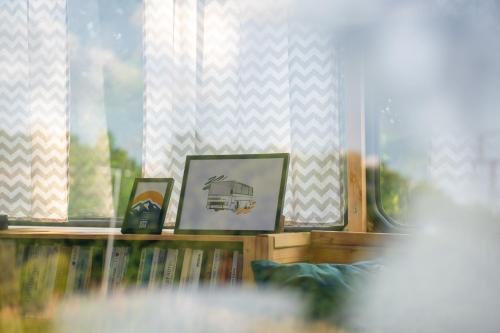 a room with a book shelf with books and a window at Autobuseek - Unique Stay in Karosa 735 in Liptovský Mikuláš