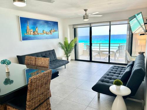 a living room with blue furniture and a view of the ocean at Sparkling Ocean View in Cancun in Cancún