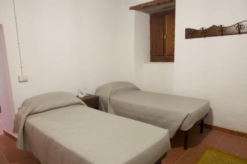 a room with two beds in a room at Rebeccu Arte e Ospitalità - Ostello in Rebeccu