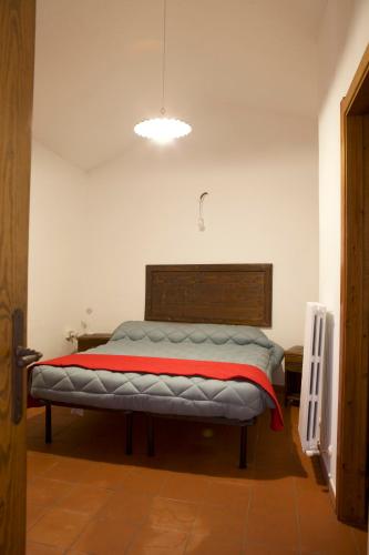 a bedroom with a bed with a red blanket on it at Rebeccu Arte e Ospitalità - Ostello in Rebeccu