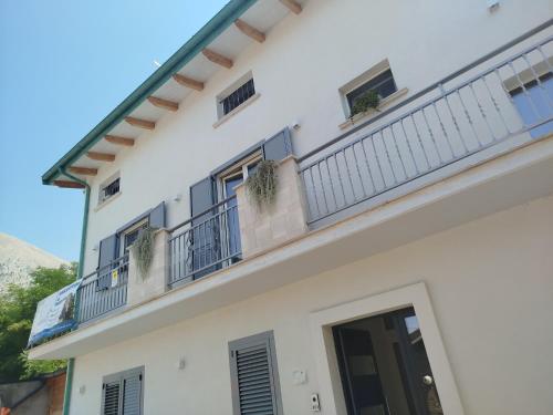 a white building with a balcony with plants on it at La Chioma di Berenice in Celano