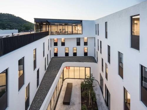 an aerial view of a white building with a courtyard at Auberge de Jeunesse HI Cahors in Cahors