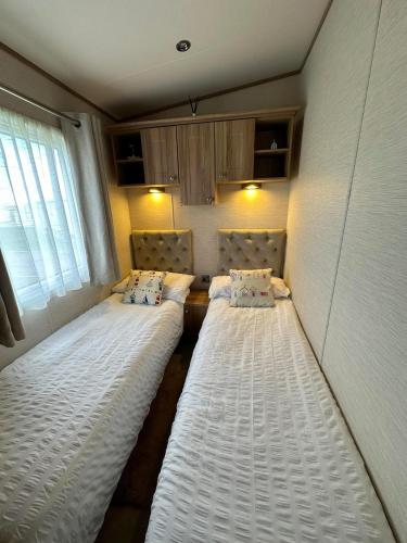two beds in the corner of a room at Jen's Retreat in Lossiemouth