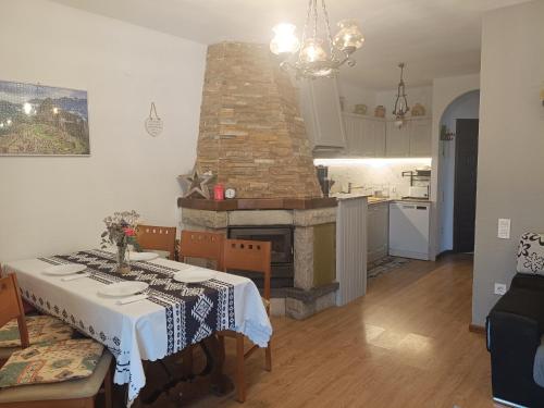 a kitchen and dining room with a table and a fireplace at Bella Terra 2 in L'Ampolla