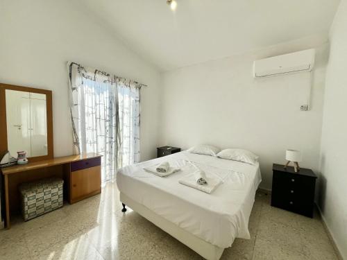 a bedroom with a white bed and a mirror at STAY Pervolia Maisonette in Sophtadhes