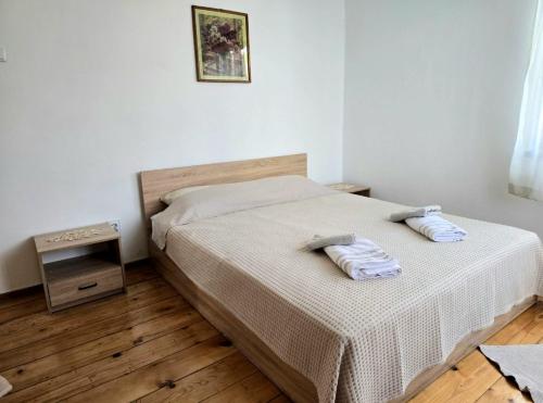 a bedroom with a bed with two pillows on it at Къща за гости Странджа in Malko Tŭrnovo