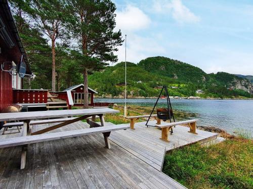 een picknicktafel op een steiger naast het water bij 8 person holiday home in Sundlandet in Snildal