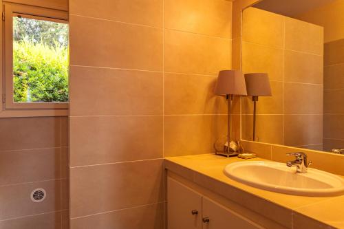 un baño con lavabo y espejo en Villa Pina, en Sainte-Lucie de Porto-Vecchio