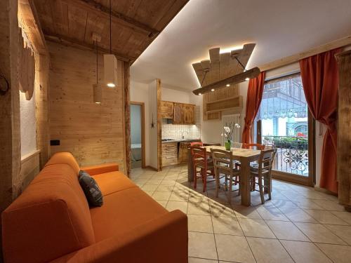 a living room with an orange couch and a table at Casa Dorigoni Molveno in Molveno