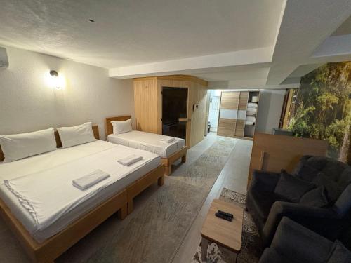 a hotel room with a large bed and a couch at Hotel Inn in Prizren