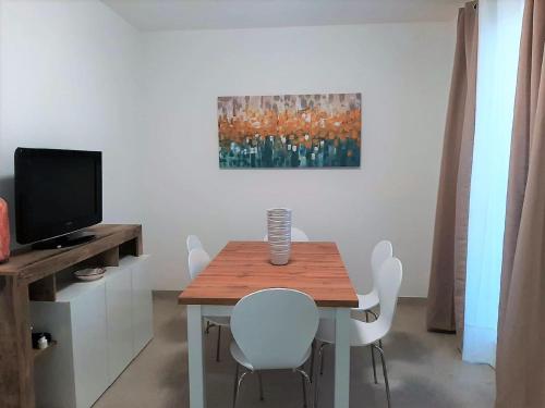 a dining room with a table with white chairs and a painting at Modern Villa Near Trapani in Locogrande