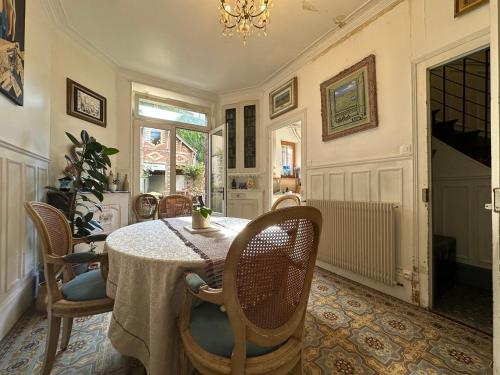 a dining room with a table and chairs and a chandelier at Logement entier hyper centre Chartres in Chartres