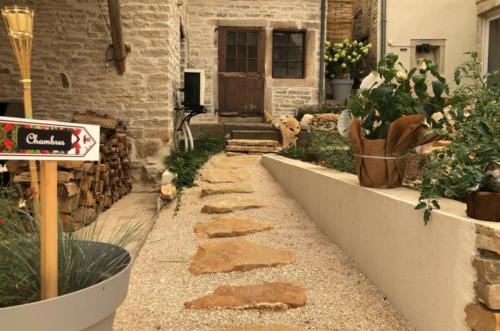 Un jardín con un camino de piedra frente a un edificio. en Gite de Bourgogne, en Sainte-Marie-sur-Ouche