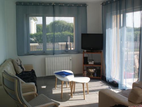 a living room with a couch and a table and a tv at Holiday Home in Audresselles by Seacoast in Audinghen