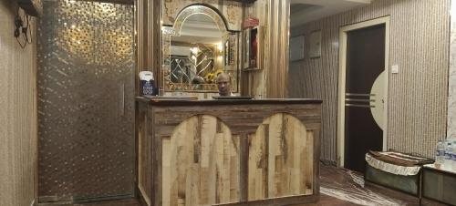a wooden bar in a room with a mirror at M hotel kidwai tower Near Esplanade New Market in Kolkata