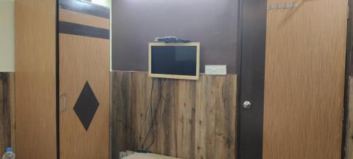 a tv sitting on top of a wooden wall at M hotel kidwai tower Near Esplanade New Market in Kolkata