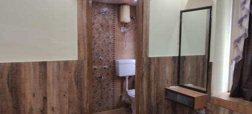 a bathroom with a toilet and a mirror at M hotel kidwai tower Near Esplanade New Market in Kolkata