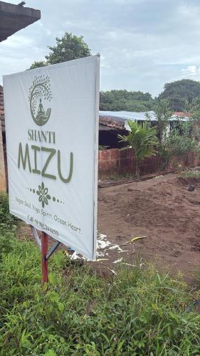 a sign for a shantini masyu in a field at shanti MIZU in Arambol
