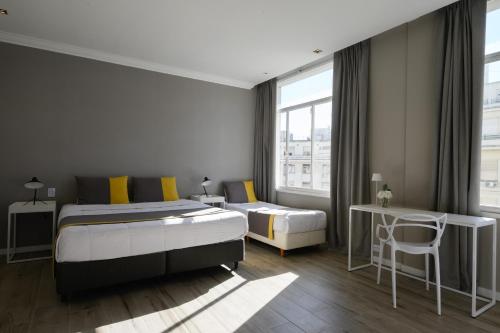 a bedroom with a king sized bed and a desk at Midtown Boutique Hotel in Buenos Aires