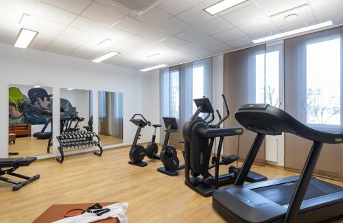 a gym with treadmills ellipticals and exercise bikes at Leonardo Hotel Munich City East in Munich