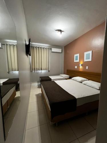 a bedroom with two beds in a room at Hotel Astória Maringá in Maringá