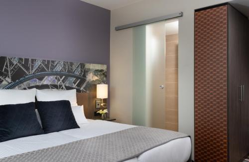 a bedroom with a large bed and a closet at Leonardo Hotel Munich City East in Munich