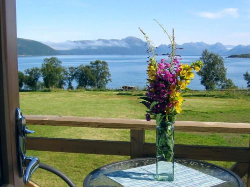 Un jarrón de flores sobre una mesa con vistas. en 6 person holiday home in ALSVÅG-By Traum, en Gisløy