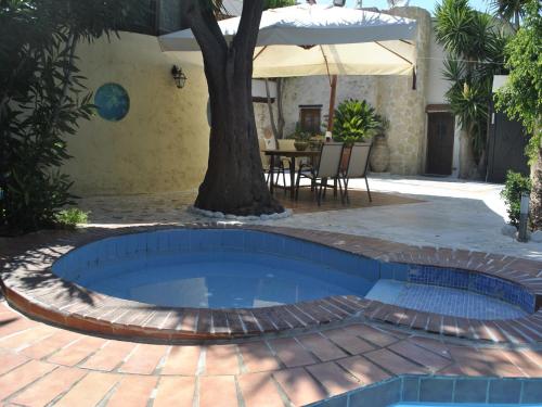 a pool with a tree in the middle of a patio at Villa in Giannoudi with Pool and Beach Nearby in Giannoudi