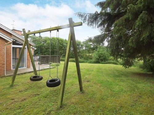 a swing set with two swings in a yard at 8 person holiday home in Hjørring-By Traum in Lønstrup