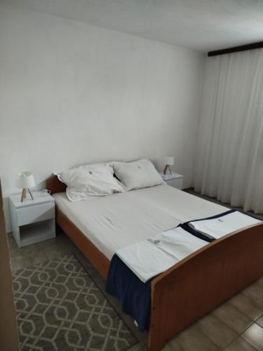 a bedroom with a large bed with two night stands at Apartmani Katarina in Rogoznica