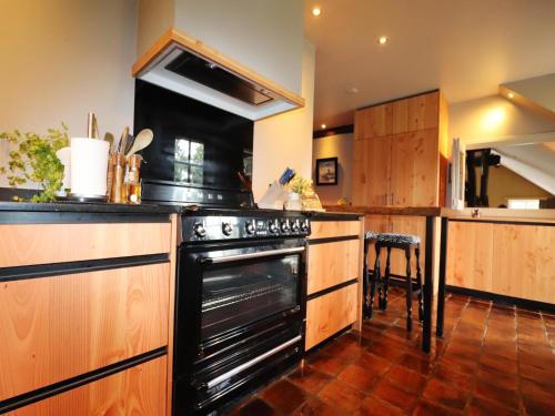 a kitchen with a black oven and a counter at Villa in Ommen with Private Pond in Rheezerveen