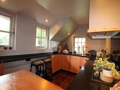a kitchen with wooden cabinets and a wooden table at Villa in Ommen with Private Pond in Rheezerveen