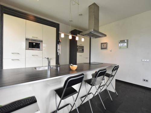 a kitchen with a counter with chairs and a sink at Villa in Luttenberg near National Park in Luttenberg