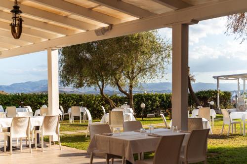 a group of tables and chairs under a pergola at Hotel dP Olbia - Sardinia in Olbia