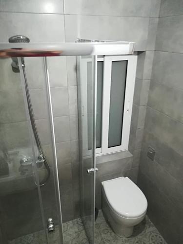 a bathroom with a toilet and a sink and a mirror at Cozy Apartment in the Heart of Qala in Qala