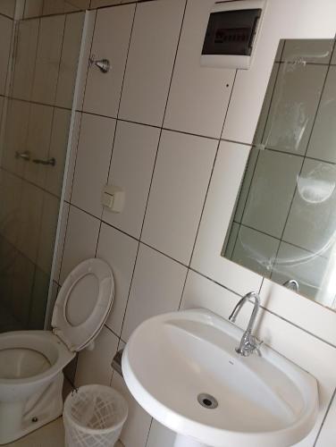 a bathroom with a sink and a toilet and a mirror at Hotel Castro Alves Norte in Marília