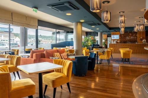 a restaurant with couches and tables and chairs at Hotel Le Grand Pavois in Fécamp