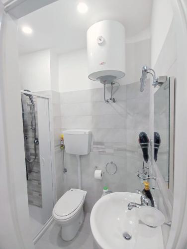 a white bathroom with a toilet and a sink at Dimora dello Stretto Intero Appartamento 4 posti Self Check-in Cucina Lavatrice Vicino Policlinico in Messina
