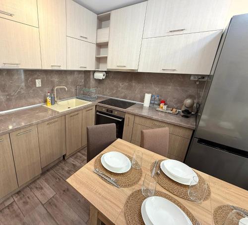 - une cuisine avec une table en bois et 2 assiettes dans l'établissement Уютен двустаен Гранд мол, à Varna